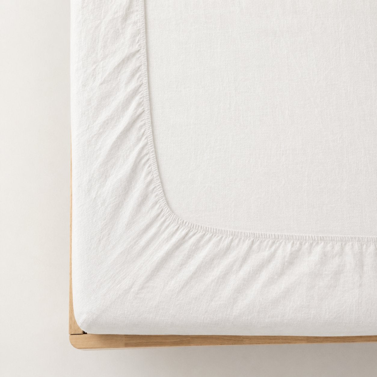 Premium linen fitted sheet in white — corner detail showing elastic hem