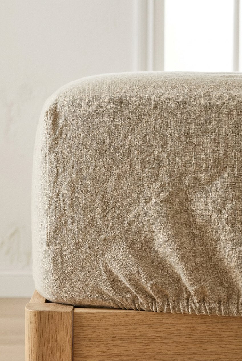 Premium linen fitted sheet in white on oak bed — side view with eucalyptus